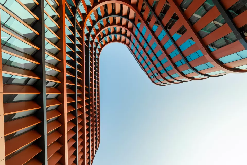 Low-angle architectural view looking up through the curved office façade
