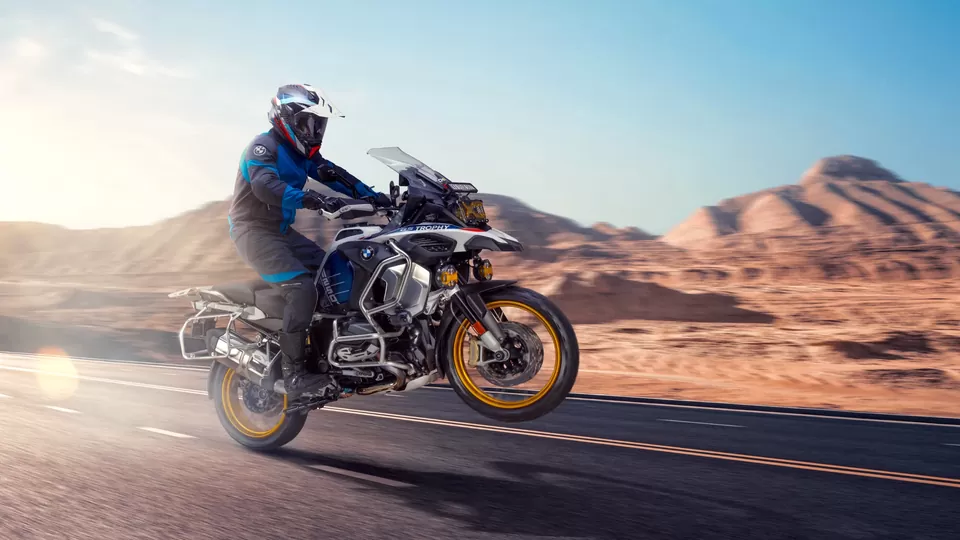 Adventure motorcycle and rider in motion against a rocky landscape